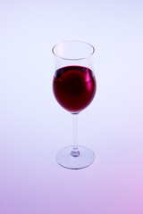 Red wine in glass isolated on white pink background.