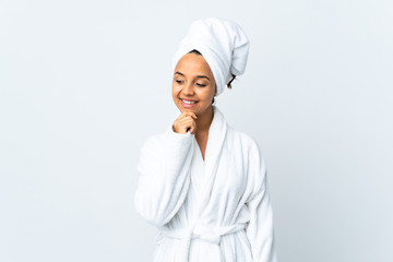 Young woman in bathrobe over isolated white background looking to the side and smiling