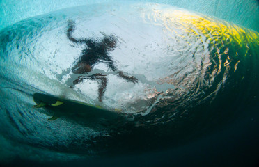 underwater shot silhouette of a surfer riding a wave