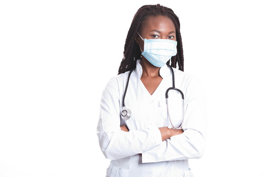 Female American African Doctor, Nurse Woman Wearing Medical Coat With Stethoscope And Mask. Happy Excited For Success Medical Worker Posing On Light Background. Pandemia Concept, Covid 19