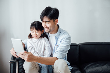 Father and daughter at home using a Tablet PC