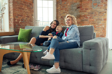 Obraz premium Emotions. Mother, son and sister at home having fun. Holidays, family, comfort, cozy concept, celebrating birthday. Beautiful caucasian family. Spending time together, playing, laughting greeting