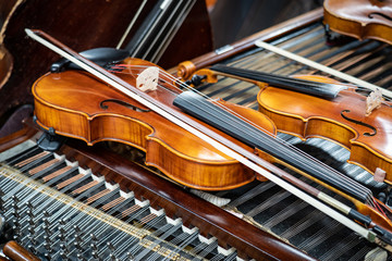 Antique violin and violin bow lying on dulcimer. Close up a violin instrument and cymbal before a concert. Music concept background