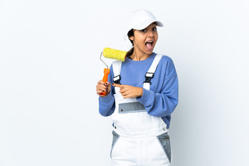 Painter woman over isolated white background surprised and pointing side