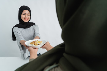 hijab woman and friend having ketupat together. rice cake for hari raya kareem