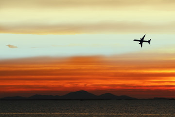 Fototapeta na wymiar silhouette airplane on sky in sunset back on cloud white orange yellow red color