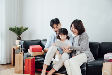 Fototapeta premium Mom and Dad and daughter at home using a Tablet PC