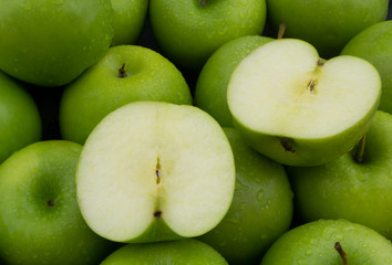 Many green apples with water drops close up