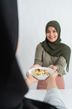 hijab woman and friend having ketupat together. rice cake for hari raya kareem