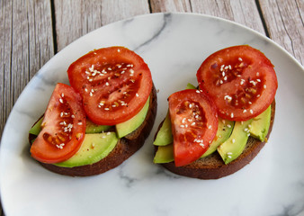 Sandwich with avocado, tomato and sesame seeds