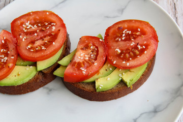 Sandwich with avocado, tomato and sesame seeds