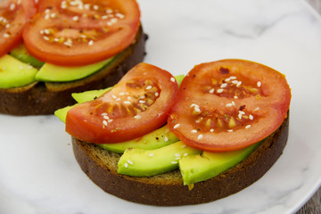 Sandwich with avocado, tomato and sesame seeds