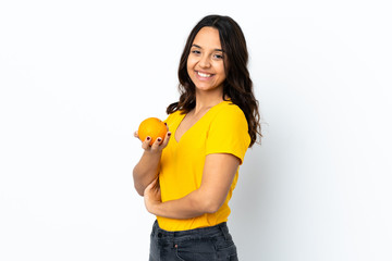 Young woman over isolated white background holding an orange