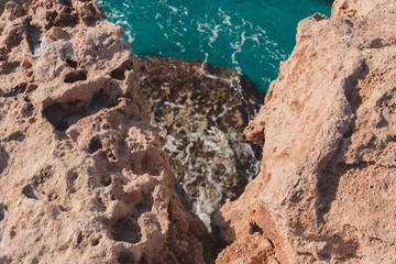 Texture of Volcanic rock surface in Cyprus. cliff, sea in the background. selective focus