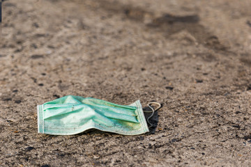 old mask that was worn by Covid-19 Being abandoned incorrectly on the concrete floor