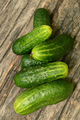 Fresh cucumbers on a wooden table close-up.