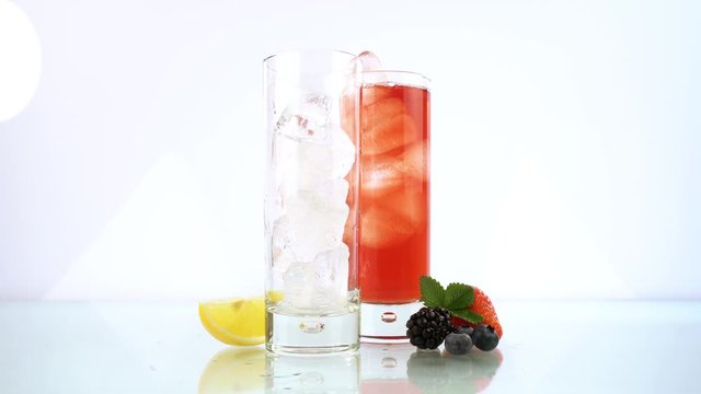 Pouring Berry and Lemon Ice Tea in a Glass isolated on white Background