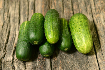 Fresh cucumbers on a wooden table close-up.