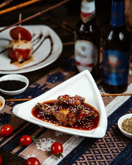 fried meat pieces in sauce with sesame