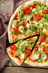 Flatbread homemade vegan pizza. Italian classic pizza with tomato cherry, mozzarella cheese and fresh arugula, copy space