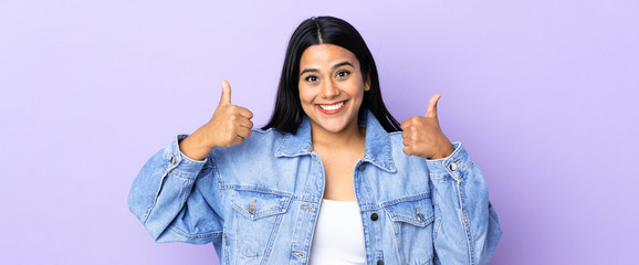 Young latin woman woman over isolated background giving a thumbs up gesture