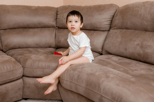 Toddler Boy Brunette Plays At Home on the Couch