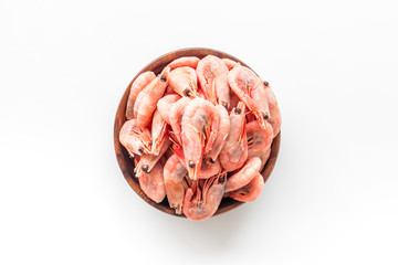 Shrimps in shell in bowl on white background top-down copy space