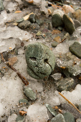 On the shore, one stone stands apart from the others. A small stone shows a face.