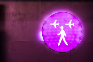 Purple sign with neon light at an international airport. Flight connections sign. Travelling by...