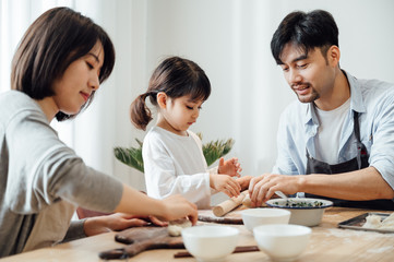 Mom and Dad and daughter at home dumplings