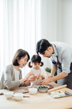Mom and Dad and daughter at home dumplings