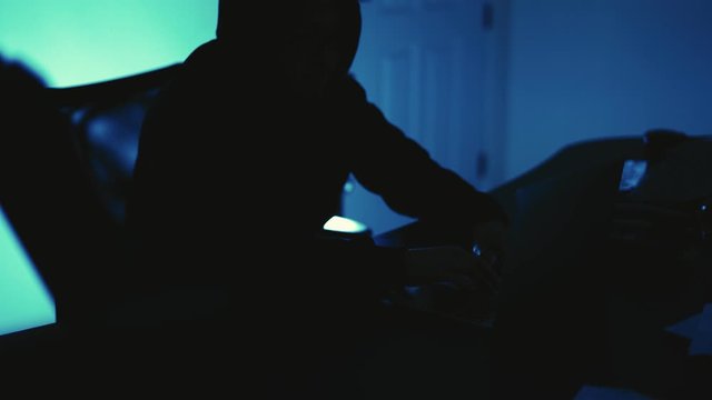 A computer programmer or hacker prints a code on a laptop keyboard to break into a secret organization system.