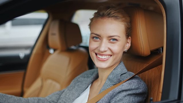Closeup woman rolling down car window. Businesswoman sitting on front seat