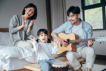 Mom and Dad and daughter sing at home
