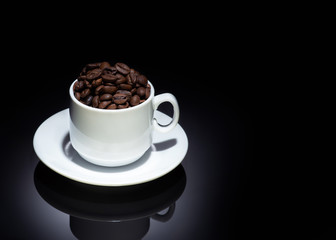 Cup with coffee beans on a dark background