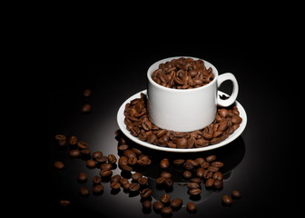 Cup with coffee beans on a dark background