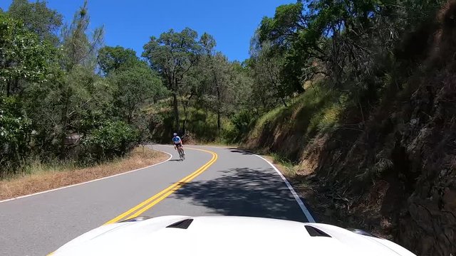 Front view of white Nissan GTR driving on scenic route, relaxing trip on sunny day