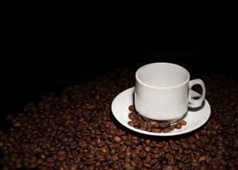 Cup with coffee beans on a dark background