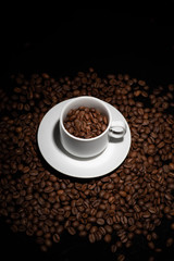 Cup with coffee beans on a dark background