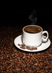 Cup with coffee beans on a dark background