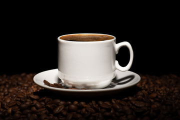 Cup with coffee beans on a dark background