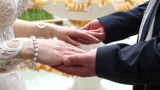 the bride gently puts her hands on the groom's hands