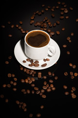 Cup with coffee beans on a dark background