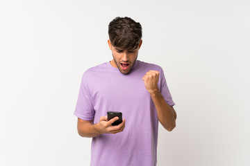 Young handsome man over isolated white background surprised and sending a message