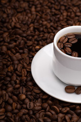 Cup with coffee beans on a dark background