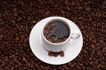 Cup with coffee beans on a dark background