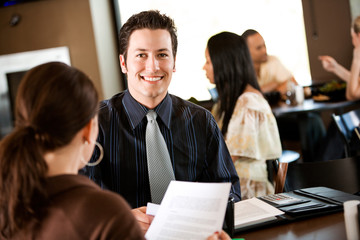 Coffee: Cheerful Businessman Looking At Documents with Co-worker