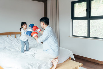 Dad and daughter playing in bed Boxing