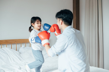 Dad and daughter playing in bed Boxing