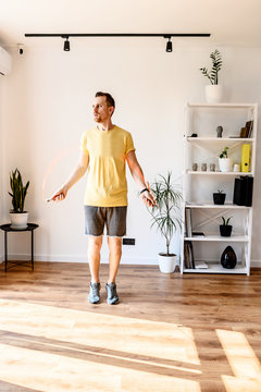 A Guy In Yellow T-shirt Jumping Rope At Home